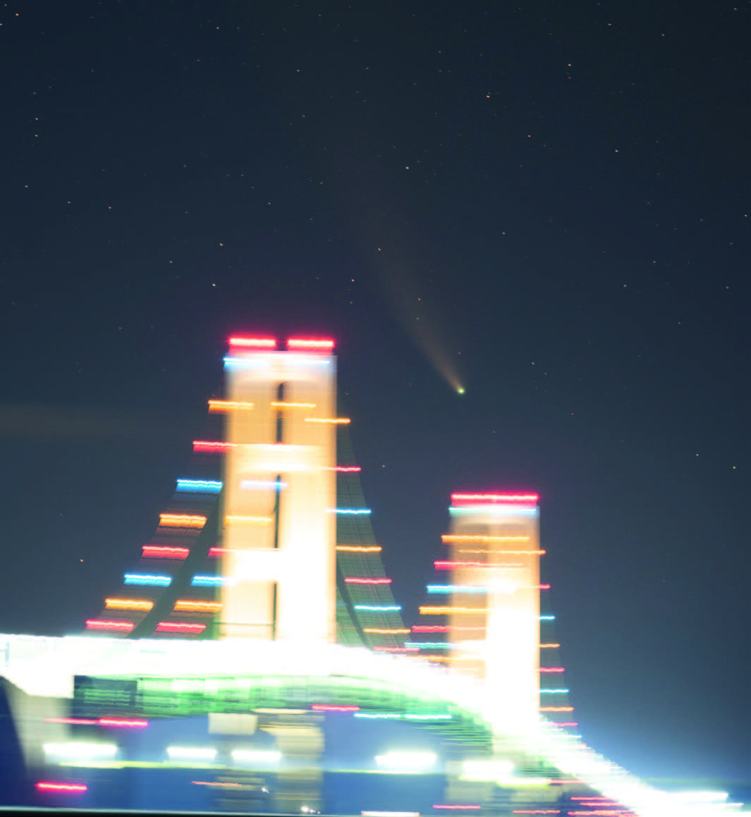in-focus comet, blurred bridge