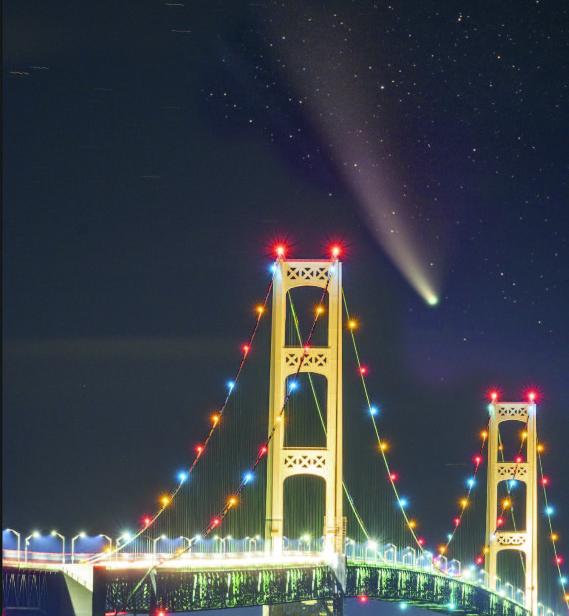 final image of comet over lit-up bridge