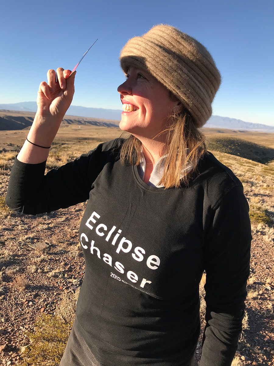 Woman holding eclipse viewer watching solar eclipse