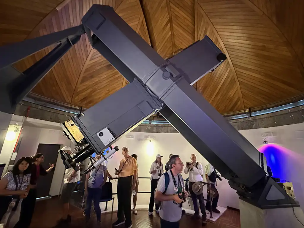 Black telescope inside wooden dome