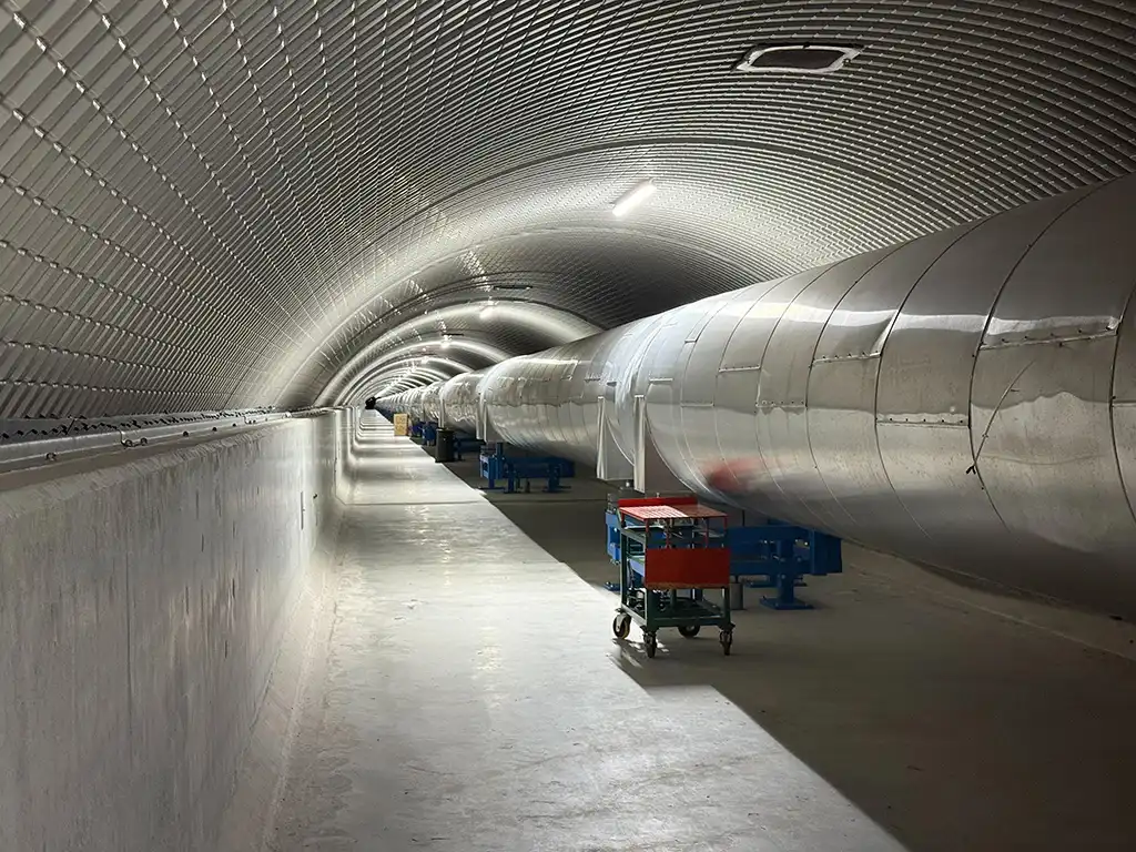 Silver column extends down a long tunnel reminiscent of subway