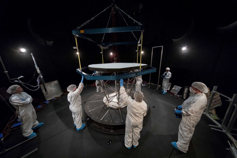 Heat shield at center with white-suited people around it