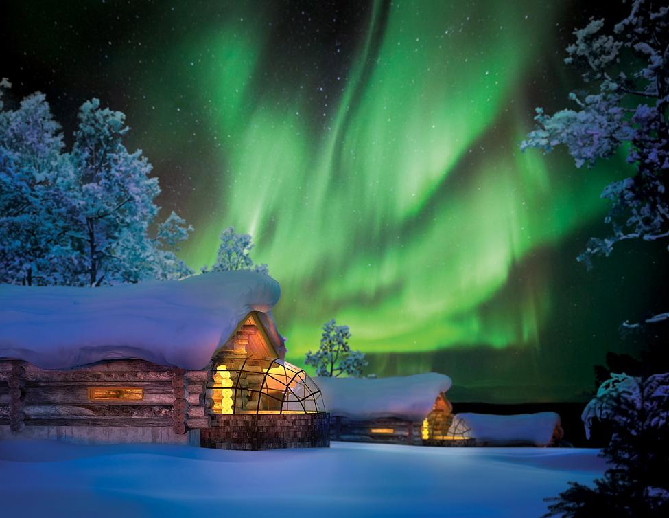 Aurora over glass log cabin in Finland