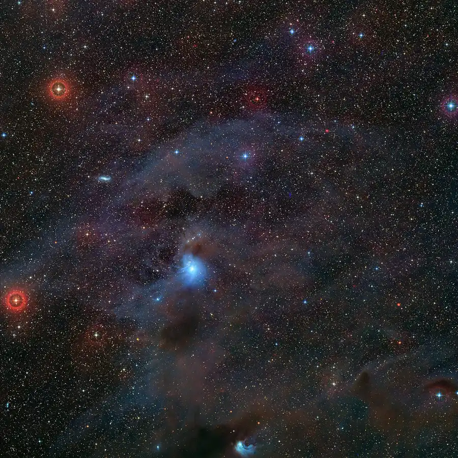 Stars dot field of black, with wisps of gas throughout the frame