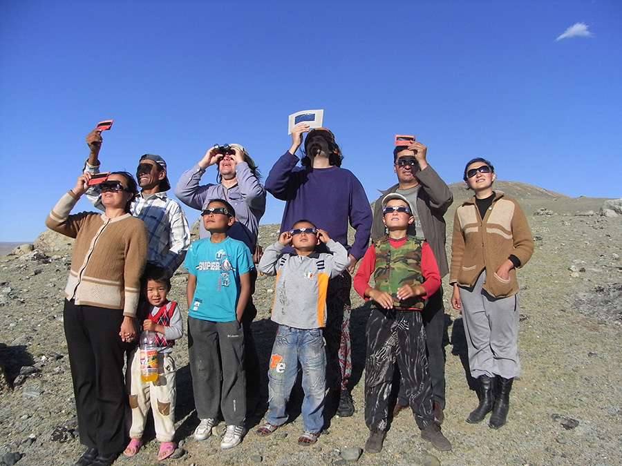 A group stands wearing eclipse glasses